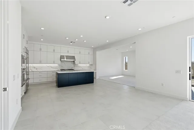 a kitchen with stainless steel appliances granite countertop a refrigerator a sink and a stove