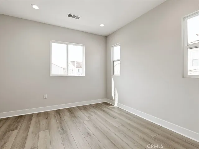 a large white bathroom with a double vanity sink a toilet a mirror and shower