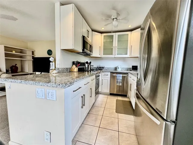 a kitchen with stainless steel appliances granite countertop a refrigerator a stove a sink and dishwasher