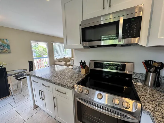a kitchen with granite countertop a stove and a microwave