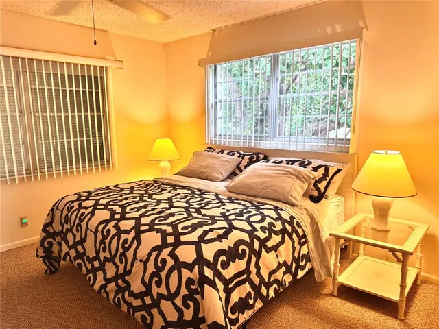 a bedroom with a bed and next to a window