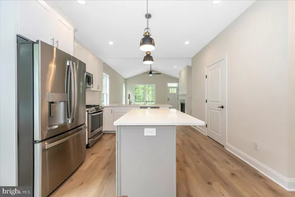 a kitchen with kitchen island a counter top space stainless steel appliances and a window
