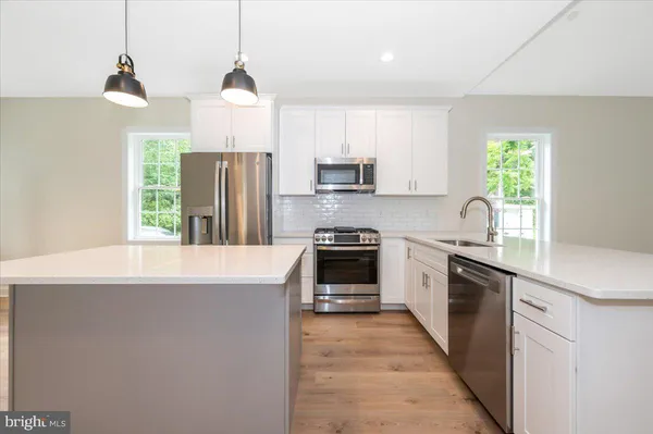 a kitchen with kitchen island granite countertop a stove a sink and a refrigerator