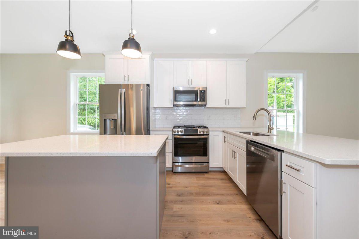 216 Brooks Lane St. Michaels, MD 21663 - Photo 15 of 37 a kitchen with kitchen island granite countertop a stove a sink and a refrigerator