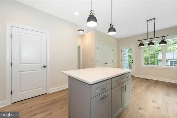 a kitchen with a stove a sink and wooden floor