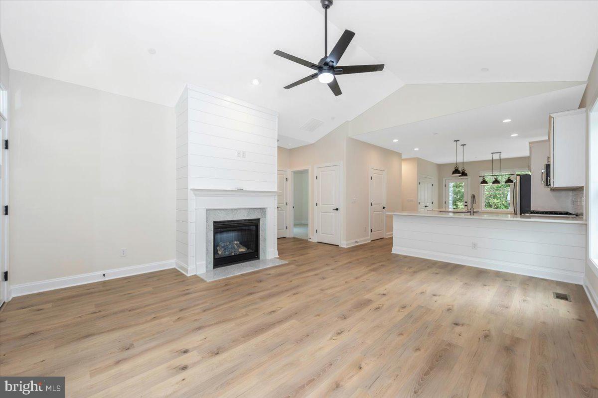 216 Brooks Lane St. Michaels, MD 21663 - Photo 6 of 37 a view of a livingroom with a fireplace a ceiling fan and wooden floor