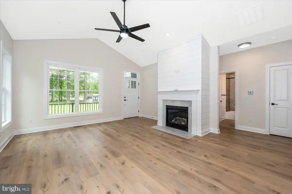 a view of a livingroom with a fireplace window and wooden floor