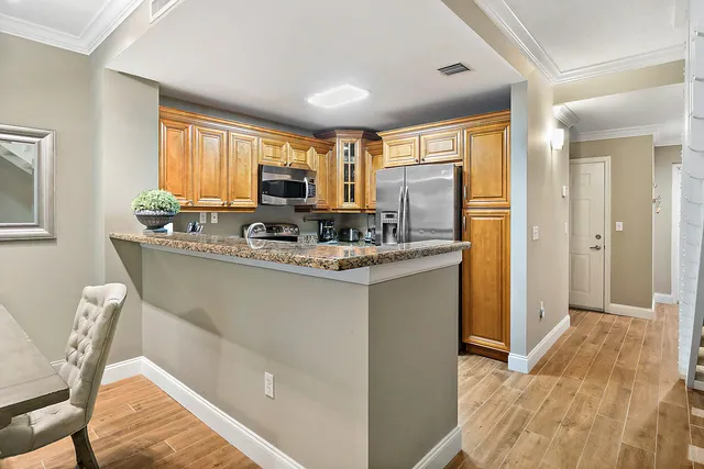 a kitchen with stainless steel appliances granite countertop a refrigerator and a stove top oven