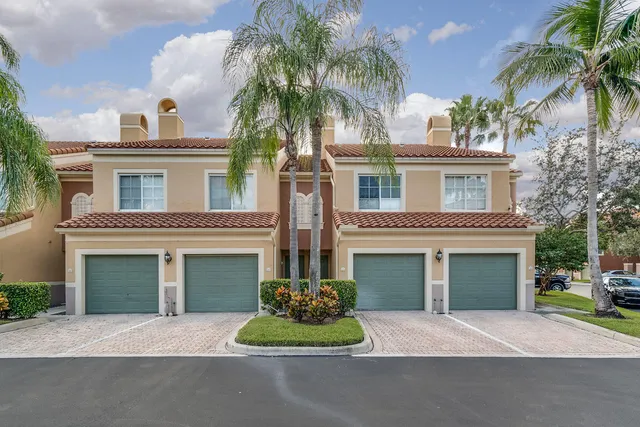 a view of a house with a yard and large trees