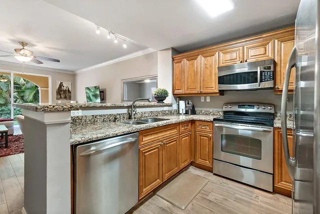a kitchen with stainless steel appliances granite countertop a stove sink microwave and cabinets