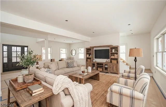 a living room with furniture flat screen tv and a large window