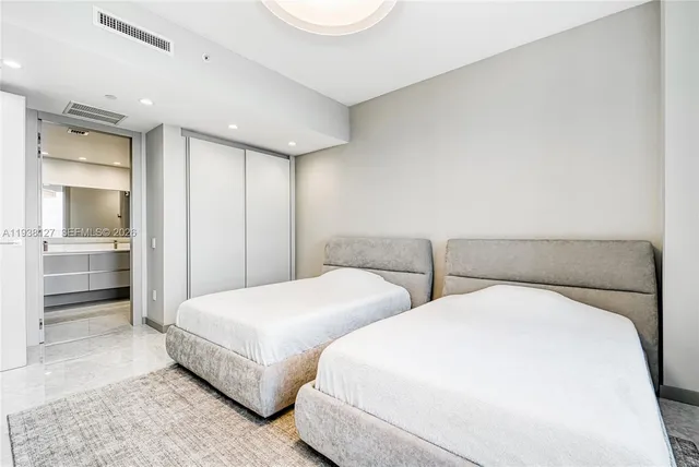 a bedroom with two beds and a walk in closet