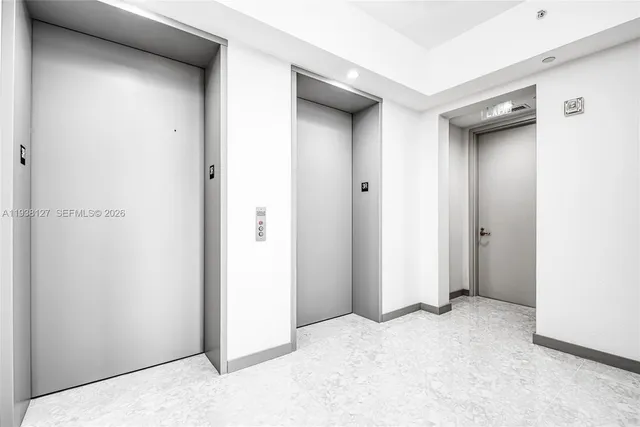 a view of an empty room with closet and a window