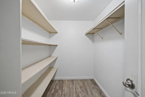 a view of walk in closet with clothes and shoes