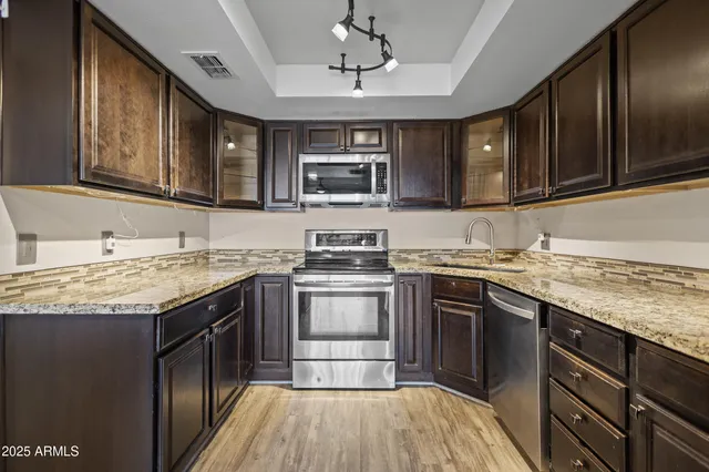 a kitchen with stainless steel appliances granite countertop a stove and cabinets