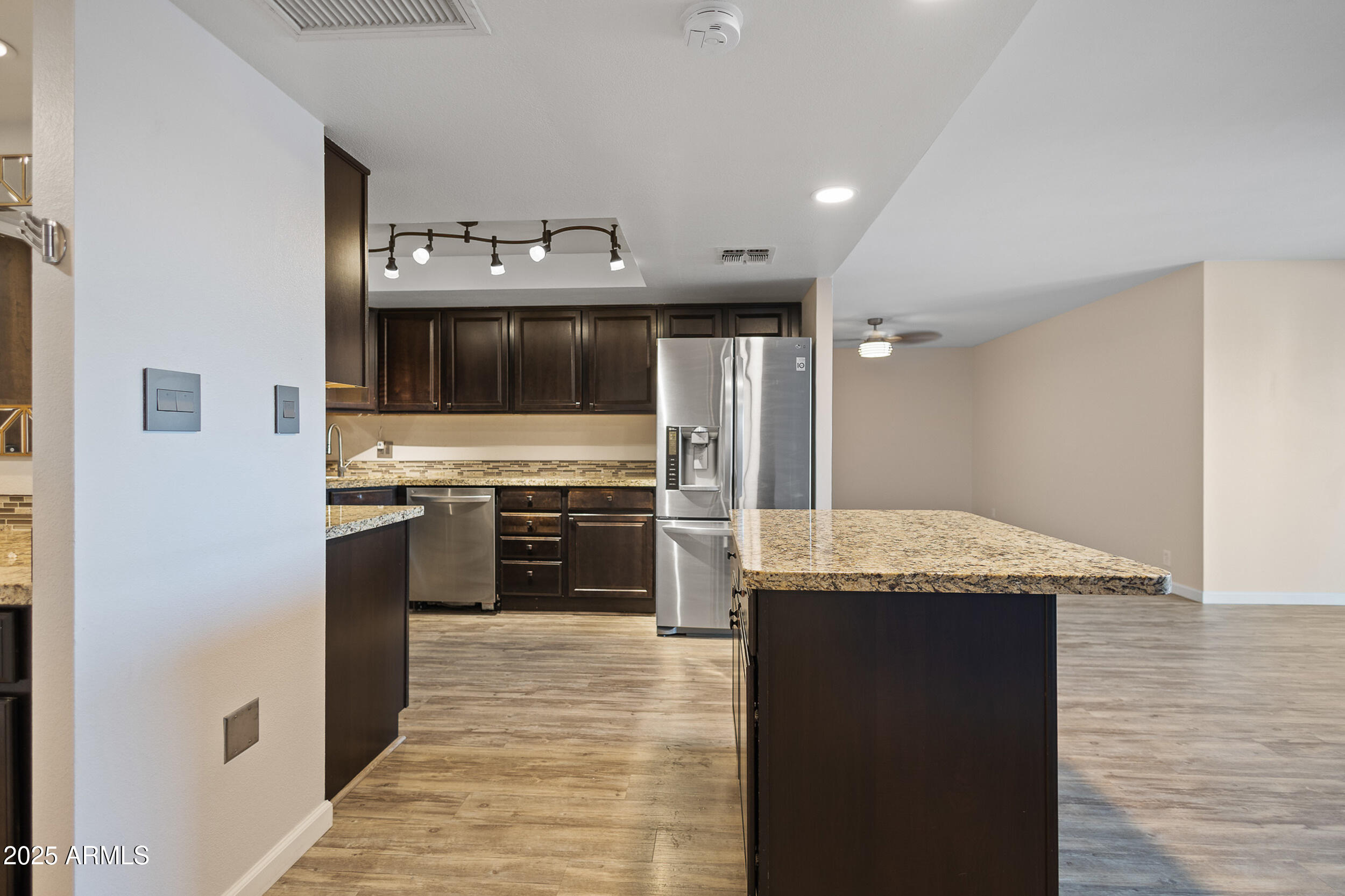 7920 East Camelback Road, Unit 601 Scottsdale, AZ 85251 - Photo 5 of 31 a kitchen with stainless steel appliances kitchen island granite countertop a refrigerator and a stove top oven