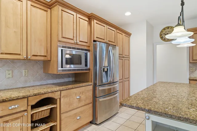 a kitchen with stainless steel appliances granite countertop a refrigerator and a stove top oven