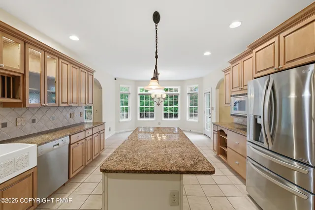 a large kitchen with kitchen island granite countertop a large counter top appliances and cabinets