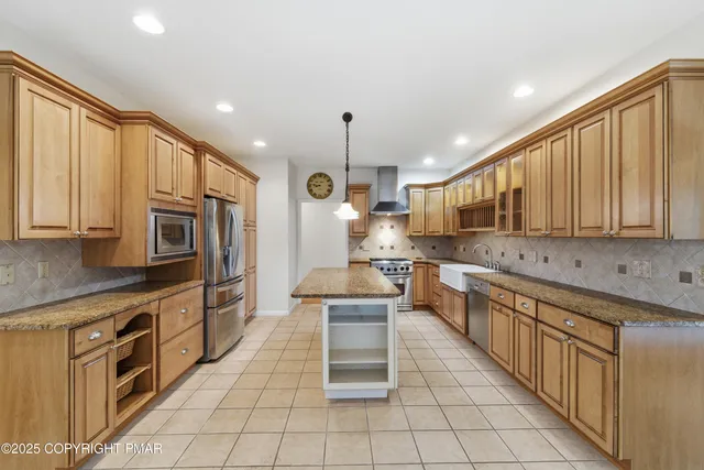 a kitchen with stainless steel appliances granite countertop a stove top oven a sink dishwasher and a refrigerator