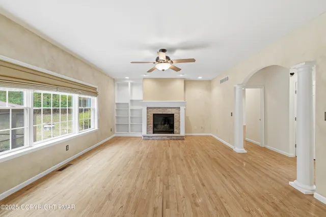 a view of an empty room with a fireplace and a window