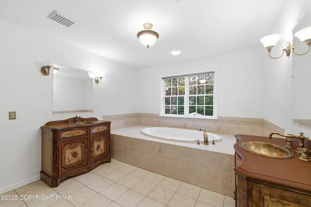 a bathroom with a tub sink and mirror