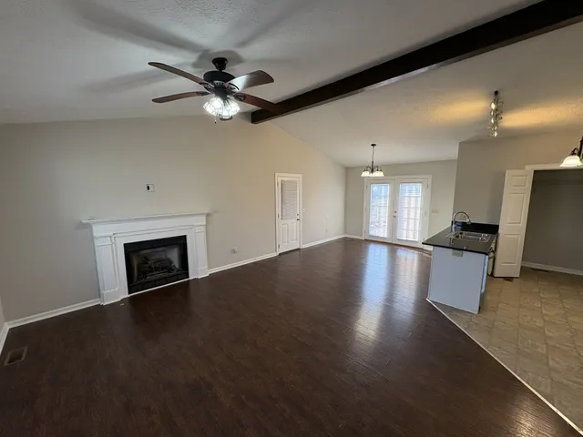 a view of a livingroom with a ceiling fan a fireplace and wooden floor