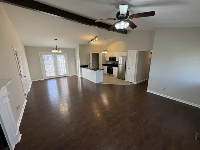 a view of a dining room with furniture a chandelier fan and wooden floor