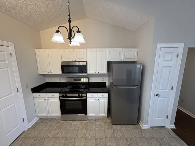 a kitchen with a stove a refrigerator and a microwave