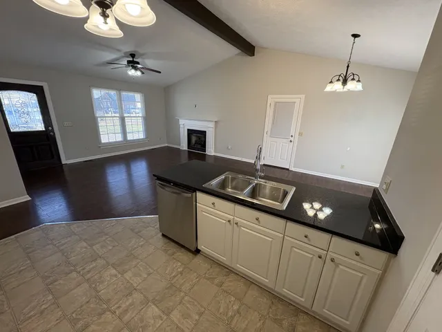 en empty room with windows and chandelier fan