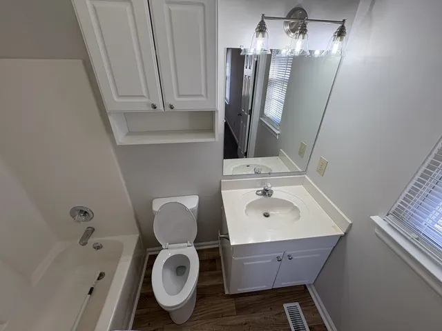 a white toilet sitting next to a bath tub