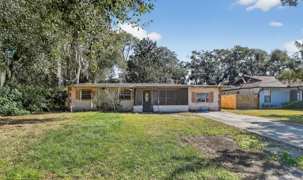 a front view of a house with a yard and trees