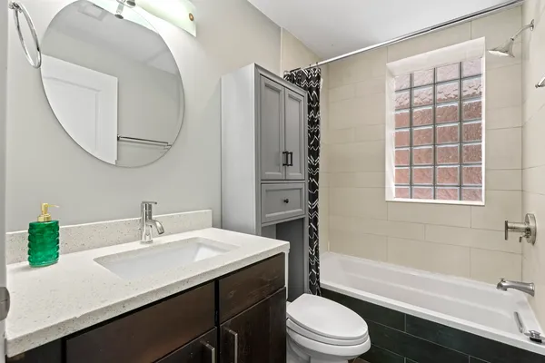a bathroom with a sink a toilet a mirror and shower