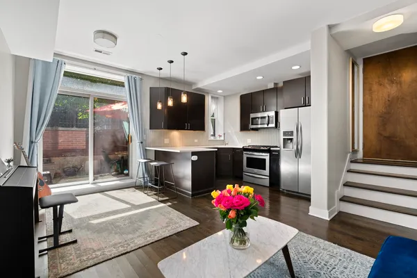 a kitchen with stainless steel appliances kitchen island granite countertop a refrigerator a stove top oven a sink and dishwasher