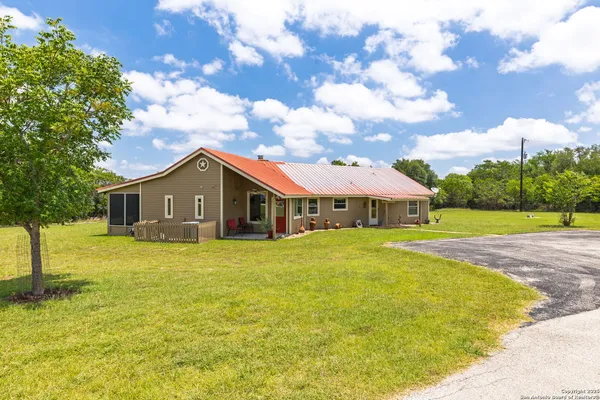 a view of a house with a yard and sitting area