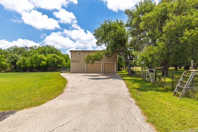 a view of a backyard with grass and a garage