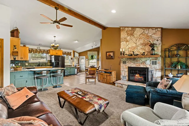 a living room with furniture kitchen view and a wooden floor