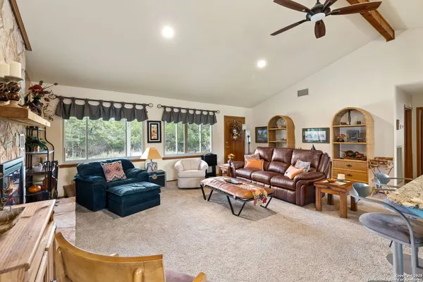 a living room with furniture a large window and a fireplace