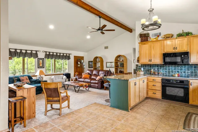 a kitchen with stainless steel appliances granite countertop a refrigerator a stove and a sink