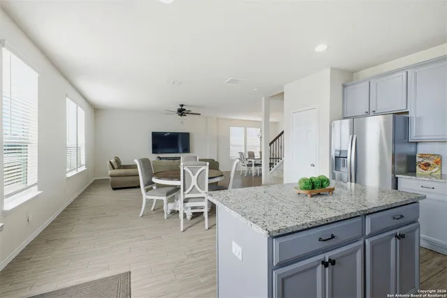 a kitchen with granite countertop kitchen island stainless steel appliances a refrigerator a stove a dining table and chairs