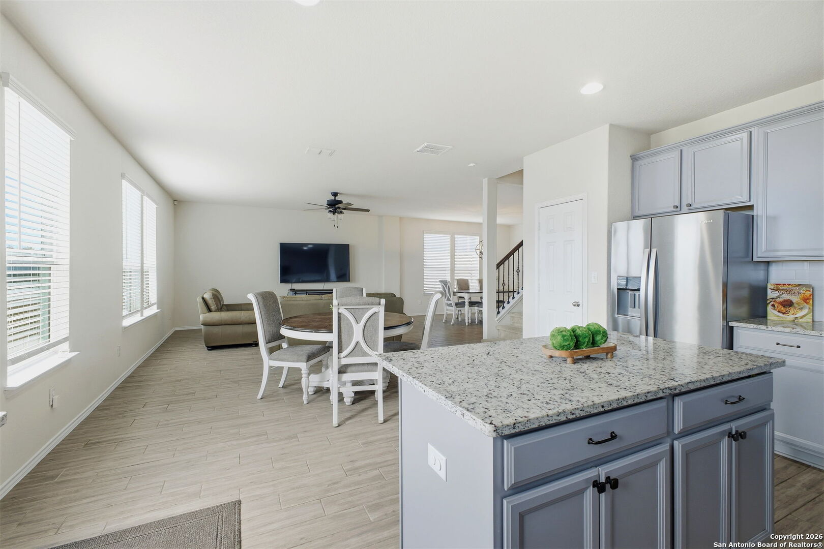 7710 Pecos Boerne, TX 78015 - Photo 13 of 34 a kitchen with granite countertop kitchen island stainless steel appliances a refrigerator a stove a dining table and chairs