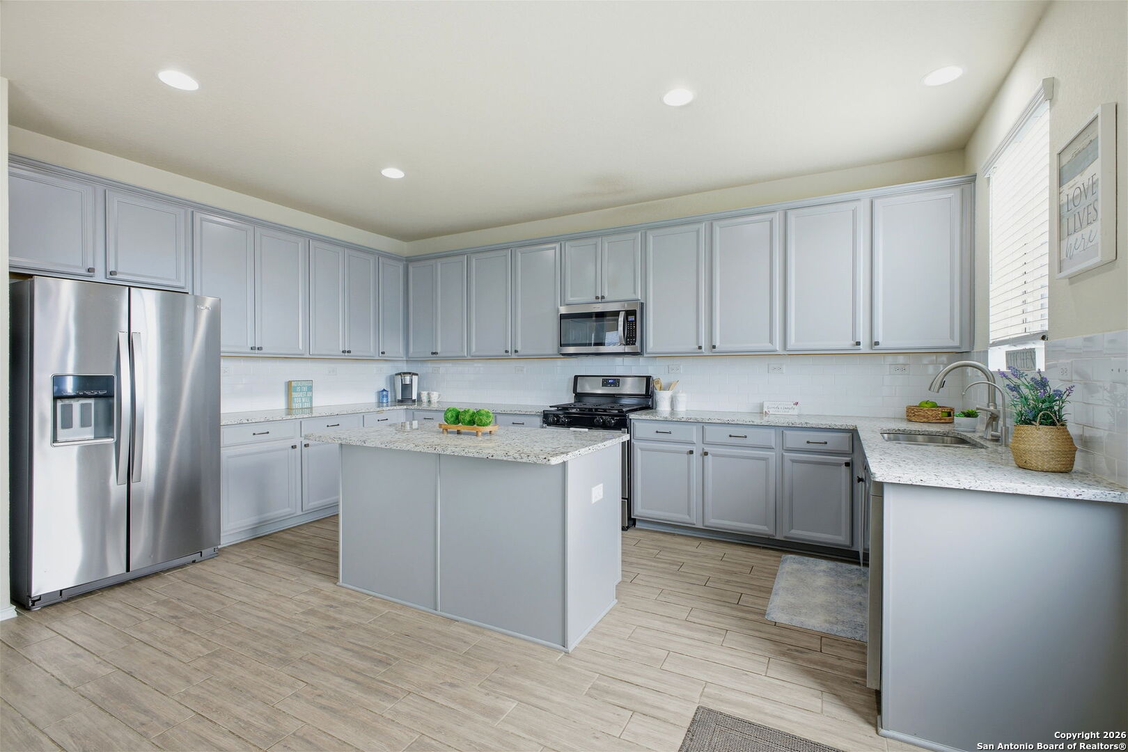 7710 Pecos Boerne, TX 78015 - Photo 14 of 34 a kitchen with white cabinets and stainless steel appliances