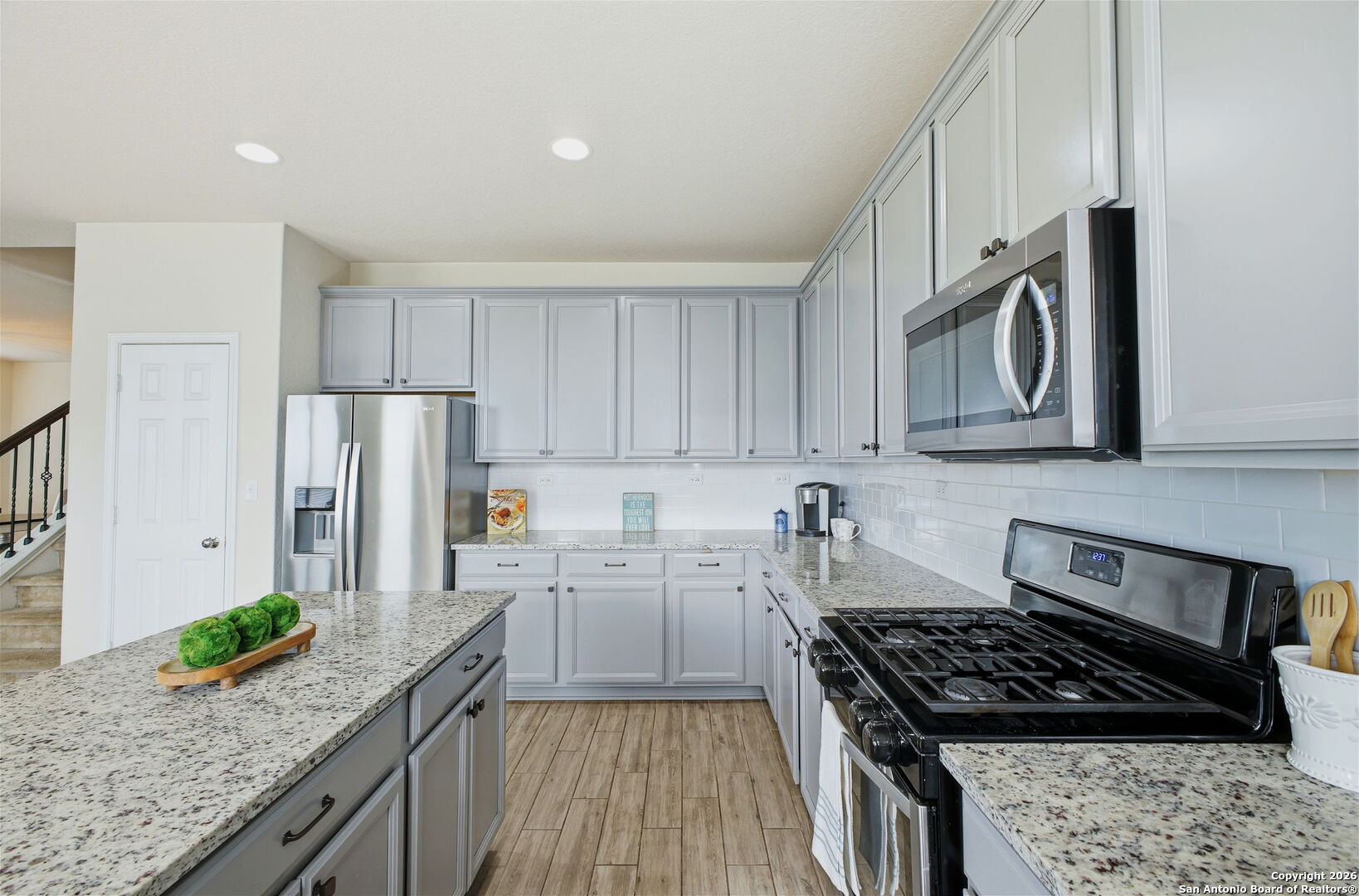 7710 Pecos Boerne, TX 78015 - Photo 15 of 34 a kitchen with granite countertop stainless steel appliances a stove a sink a refrigerator and cabinets