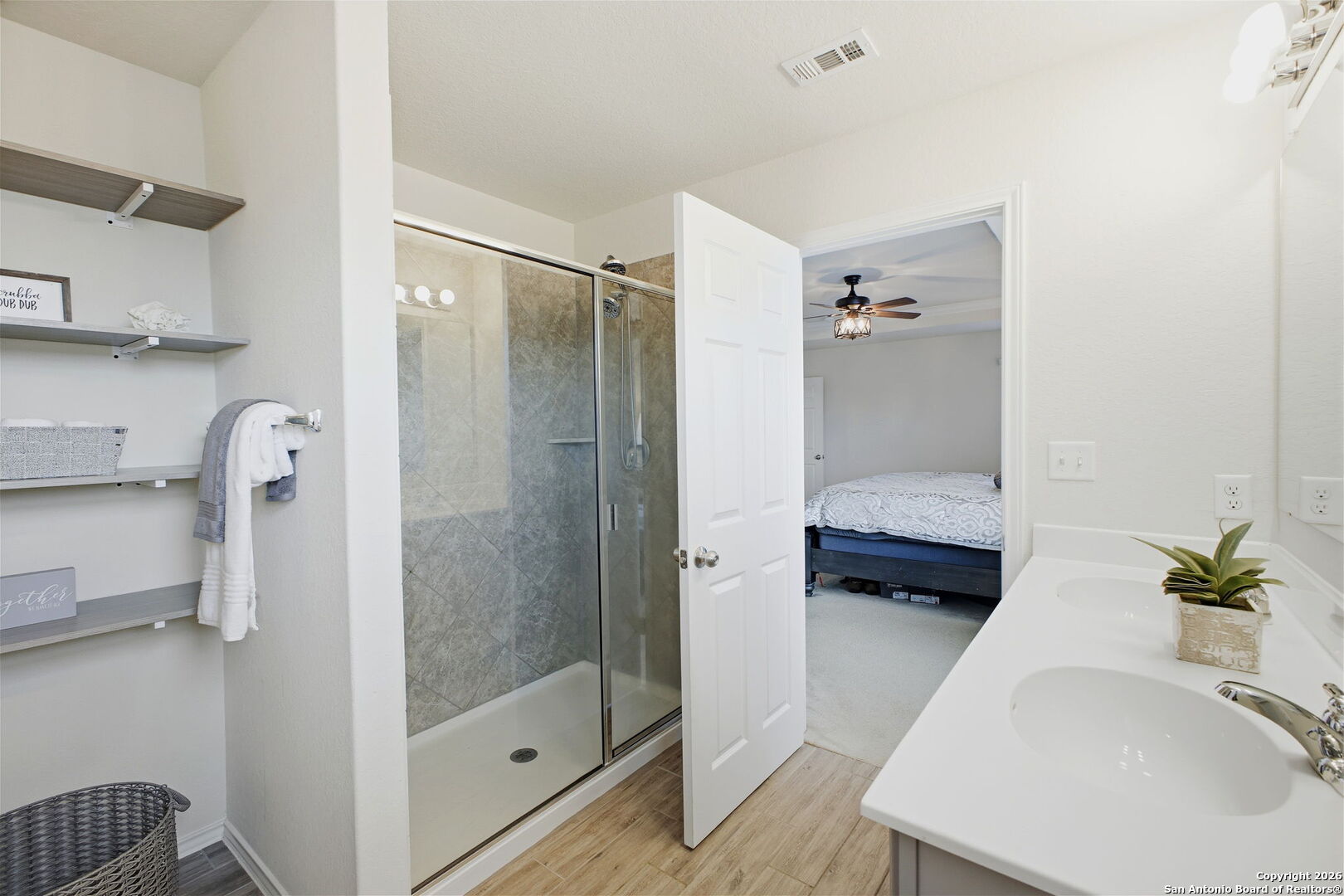 7710 Pecos Boerne, TX 78015 - Photo 19 of 34 a en suite bathroom with a granite countertop sink a mirror and shower
