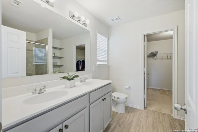 a bathroom with a sink a toilet and shower