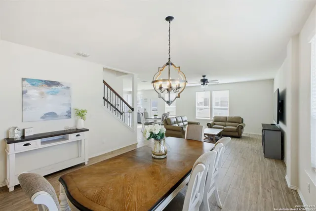 a view of a dining room with furniture a chandelier and wooden floor