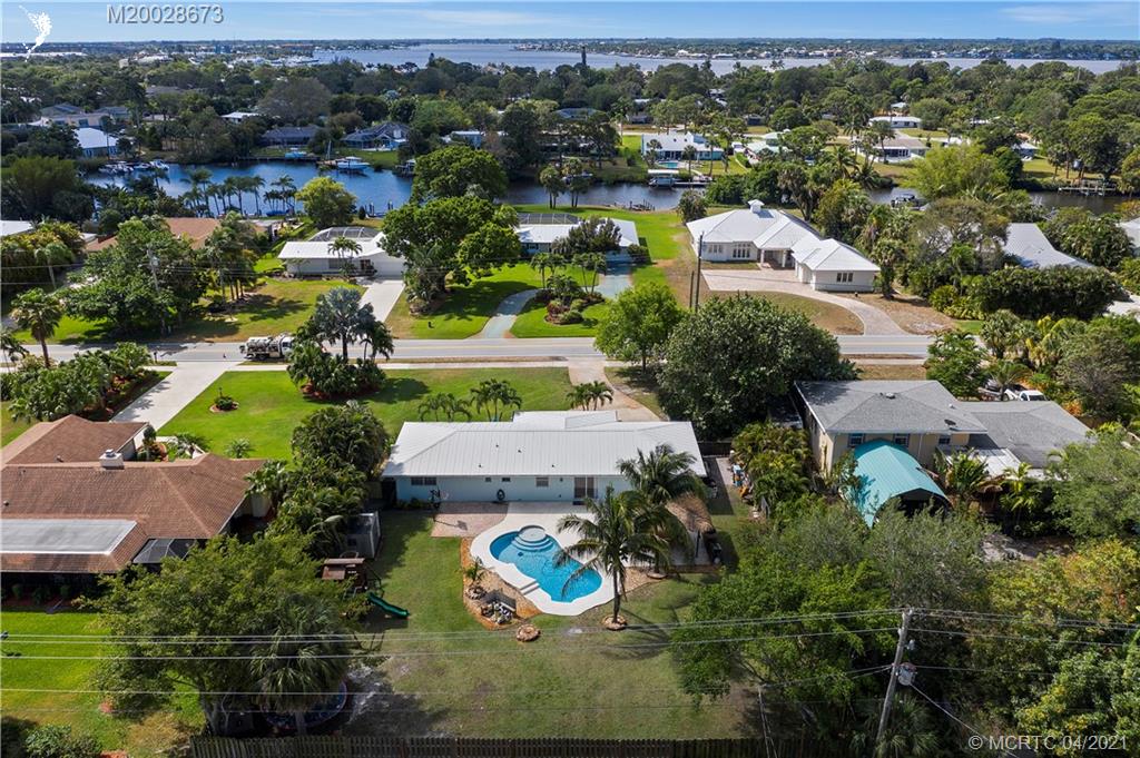 1093 Northwest Spruce Ridge Drive Stuart, FL 34994 - Photo 3 of 40 an aerial view of residential houses with outdoor space and parking