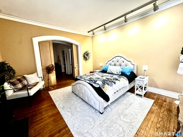 a bedroom with a bed and wooden floor