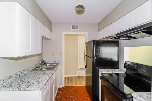 a kitchen with granite countertop a sink and a stove