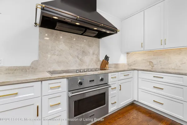a kitchen with granite countertop white cabinets and white appliances