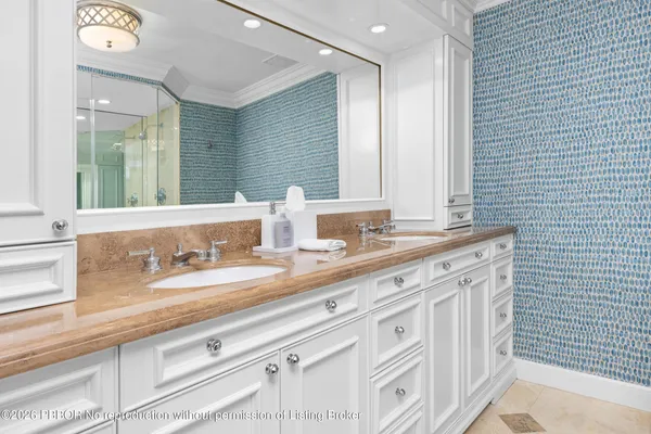 a bathroom with double vanity two mirror and a bathtub
